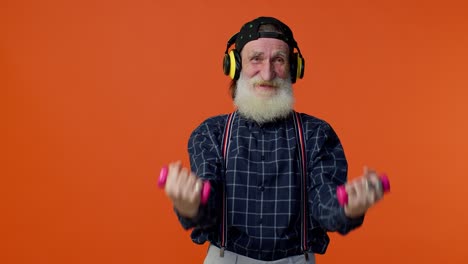 Elderly-bearded-man-listening-music-via-headphones,-working-out,-lifting-pink-dumbbells,-healthcare