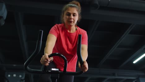 Group-of-girls-performs-aerobic-training-workout-cardio-routine-on-bike-simulators,-cycle-training