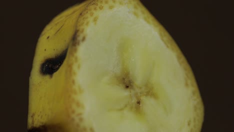 Gire-El-Trozo-De-Plátano-Sobre-Un-Fondo-Oscuro