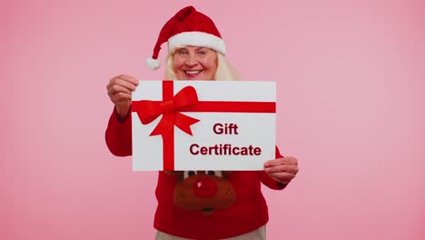 Senior-grandmother-woman-in-New-Year-sweater-presenting-card-gift-certificate-coupon-winner-voucher