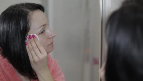 Beautiful-brunette-woman-using-cotton-pads.-Woman-removing-makeup
