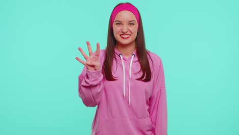Countdown-to-win-celebration,-Cheerful-girl-20s-in-hoodie-counting-in-reverse-order-from-five-to-one