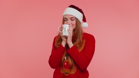 Cheerful-girl-in-Christmas-Santa-sweater-with-hot-drink-smiling,-relaxing,-drinking-coffee-or-tea