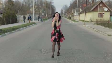 Attractive-young-woman-in-a-dress-with-flowers-walking-on-the-highway