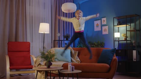 Active-funny-girl-kid-jumping,-dancing,-fooling-on-soft-cozy-sofa-at-home-spend-free-time-alone