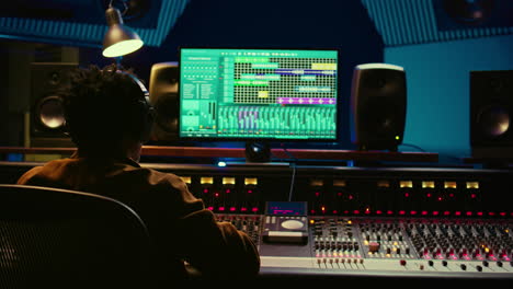 Audio-designer-leveling-sound-on-a-mixer-control-desk