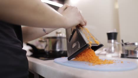 Carrots-on-a-grater-rubbed-on-the-home-kitchen.-Cutting-Carrot-Grater