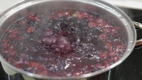 Berries-in-pot-with-boiling-water.-Cooking-compote.-Kitchen