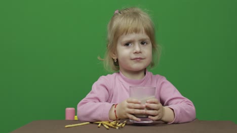 The-child-eats-cookies.-A-little-girl-is-eating-cookies-sitting-on-the-table.
