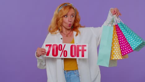 Cheerful-redhead-girl-showing-shopping-bags,-Up-To-70-Percent-Off-inscriptions-banner,-Black-Friday