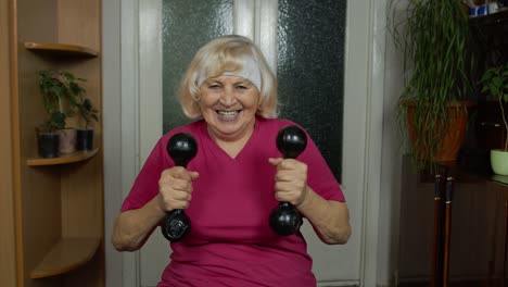 Senior-mature-grandmother-woman-doing-weightlifting-training-workout-dumbbell-exercising-at-home