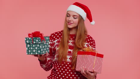 Woman-in-Christmas-red-sweater-Santa-hat,-smiling,-holding-two-gift-boxes-New-Year-presents-shopping