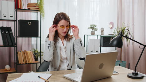 Mujer-De-Negocios-Feliz-Trabajando-En-Una-Computadora-Portátil-En-El-Escritorio-De-La-Oficina-En-Casa-Poniéndose-Auriculares-Escuchando-Música-Relajarse