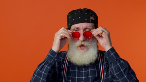 Seductive-senior-elderly-old-bearded-man-wearing-sunglasses,-charming-smile,-pointing-at-camera