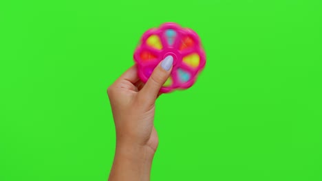 Girl-hands-playing-with-pop-it-spinner-sensory-toy-isolated-on-chroma-key,-stress-anxiety-relief
