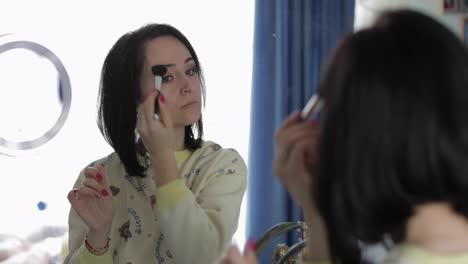Young,-pretty-woman-in-pajamas-near-mirror.-Beauty-and-makeup-concept
