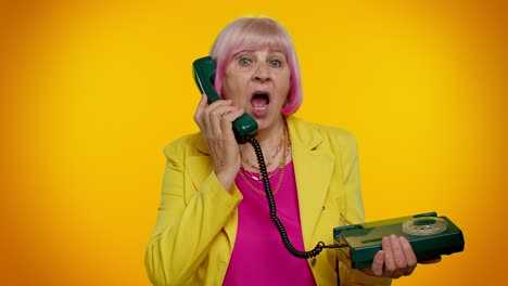 Senior-stylish-granny-woman-talking-on-wired-vintage-telephone-of-80s,-says-hey-you-call-me-back