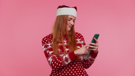 Girl-in-red-Christmas-sweater-using-mobile-phone,-hold-money-dollar-cash,-doing-online-gift-shopping