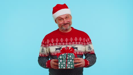 Lustiger-Mann-Trägt-Roten-Neujahrspullover-Und-Hut-Präsentiert-Weihnachtsgeschenk-Box,-Shopping-Verkauf-Feiertage