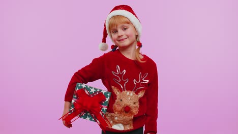 Cheerful-girl-in-Santa-sweater-presenting-two-Christmas-gift-boxes-stretches-out-her-hands-to-camera