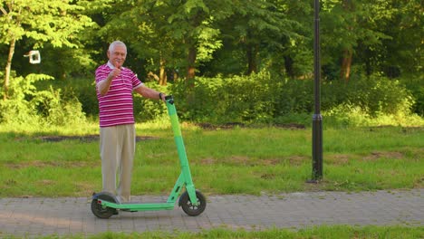 Abuelo-Hombre-Mayor-Y-Elegante-Montando-Scooter-Eléctrico-En-El-Parque,-Abuelo-Moderno-Conduciendo-Vehículo-Urbano