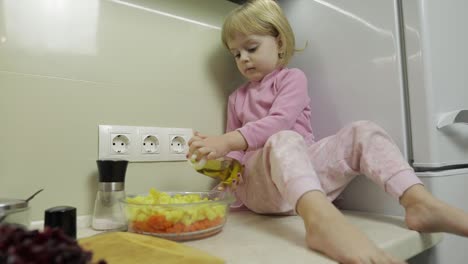 Kleines-Mädchen-Sitzt-In-Der-Küche-Und-Bereitet-Einen-Salat-Zu
