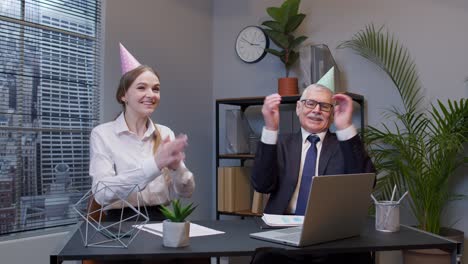 Two-joyful-collegues-in-formal-suits-dancing-victory-dance,-celebrating-success-of-business-project
