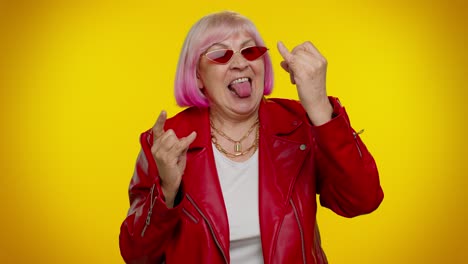 Joyful-delighted-crazy-elderly-woman-showing-rock-n-roll-gesture-by-hands,-cool-sign,-dancing