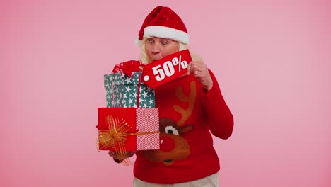 Elderly-woman-in-Christmas-sweater-showing-gift-box-and-50-Percent-discount-inscriptions-banner-text