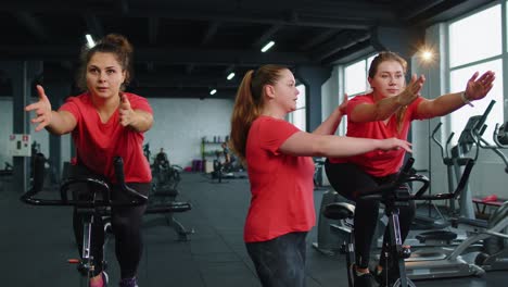Eine-Gruppe-Von-Mädchen-Führt-Aerobic-Training,-Cardio-Training-Auf-Fahrradsimulatoren-Und-Fahrradtraining-Durch