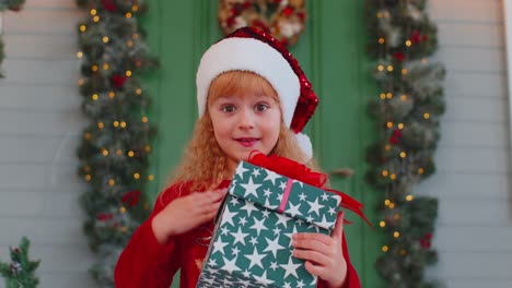 Fröhliches-Kleinkind-Im-Roten-Pullover,-Das-Eine-Weihnachtsgeschenkbox-Präsentiert-Und-Die-Hände-Ausstreckt