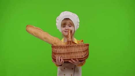 Child-girl-kid-dressed-as-professional-cook-chef-smiling-and-showing-basket-with-baguette-and-bread