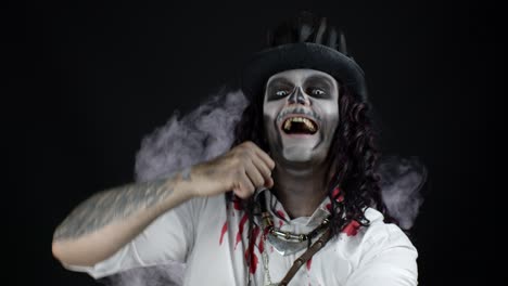 Gruseliger-Mann-Mit-Skelett-Halloween-Makeup-In-Blutigem-Hemd.-Typ-Hört-Musik,-Tanzt,-Feiert