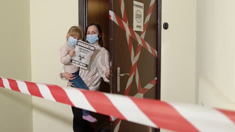 Sick-mother-with-kid-daughter-in-medical-masks-opening-home-door,-coronavirus-quarantine-lockdown