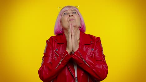 Mature-old-woman-praying-to-God-making-wish-asking-with-hopeful-imploring-expression-begging-apology