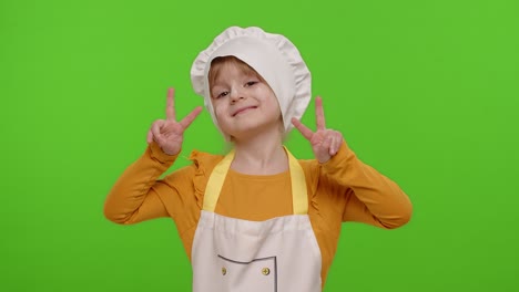 Little-child-girl-dressed-like-chef-cook-showing-victory-sign,-hoping-for-success-and-win,-peace