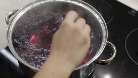 Stir-the-berries-in-pot-with-boiling-water.-Cooking-compote.-Kitchen