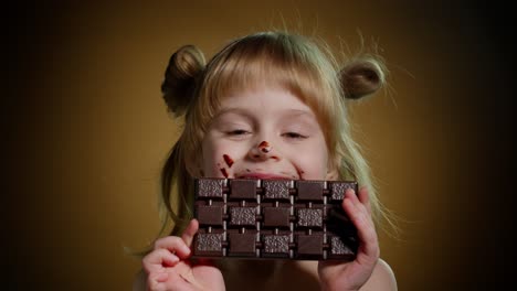 Close-up-portrait-of-teen-child-kid-girl-eating-milk-chocolate-bar,-addiction-of-sweets-and-candies