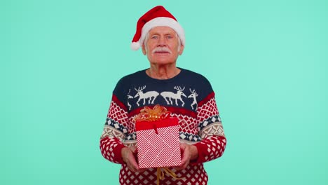 Senior-grandfather-in-New-Year-sweater-and-hat-presenting-Christmas-gift-box,-shopping-sale-holidays