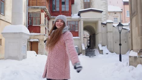 Attractive-young-girl-tourist-dancing,-celebrating,-smiling-during-her-vacation-in-old-city-center