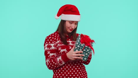Lustiges-Mädchen-Trägt-Neujahrspullover-Hirschgeweih-Erhalten-Geschenk,-Interessiert-An-Dem,-Was-In-Geschenk-Box