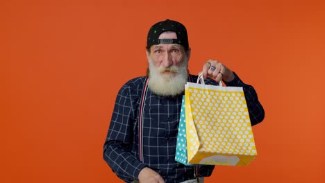 Senior-bearded-man-showing-shopping-bags-and-Up-To-50-Percent-Off-inscriptions-banner,-Black-Friday