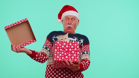 Großvater-Im-Weihnachtspullover-Lächelt,-Packt-Geschenk-Aus,-öffnet-Schachtel-Mit-Hauskatze,-Tolle-Überraschung