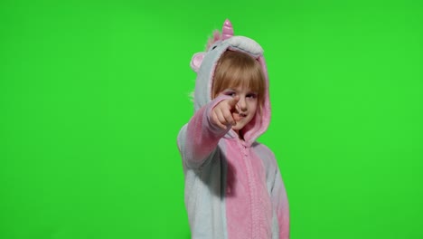 Little-child-girl-smiling,-pointing-at-camera,-making-gun-gesture-with-hands-in-unicorn-pajamas
