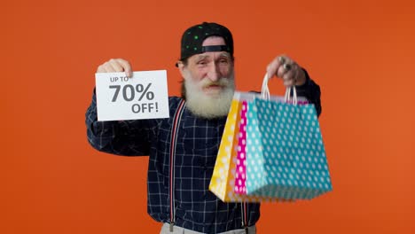 Senior-bearded-man-showing-shopping-bags-and-Up-To-70-Percent-Off-inscriptions-banner,-Black-Friday