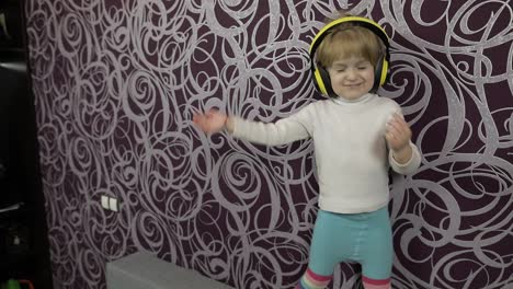 Un-Niño-Feliz-Bailando-En-El-Sofá-Y-Escuchando-Música-Con-Auriculares-En-Casa