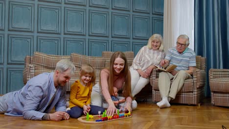 Family-leisure-at-home,-child-kid-daughter-playing-with-mother-and-father-railway-train-toy-game