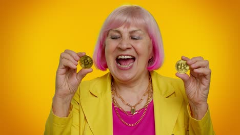 Anciana-Y-Elegante-Abuela-Mostrando-Bitcoins-Dorados,-Tecnología-Minera-De-Inversión-En-Criptomonedas