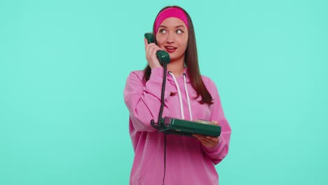Cheerful-teen-girl-secretary-talking-on-wired-vintage-telephone-of-80s,-says-hey-you-call-me-back