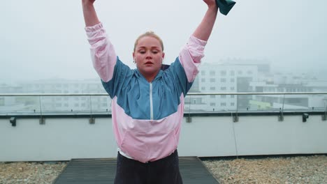 Sportliches-Mädchen-In-Sportbekleidung-Macht-Yoga-Stretching-Übungen-Mit-Gummiband-Auf-Dem-Dach-Des-Hauses-Im-Freien